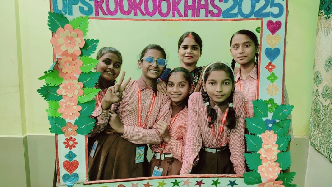 Students and a teacher smiling inside a decorated UPS Roorookhas 2025 photo frame