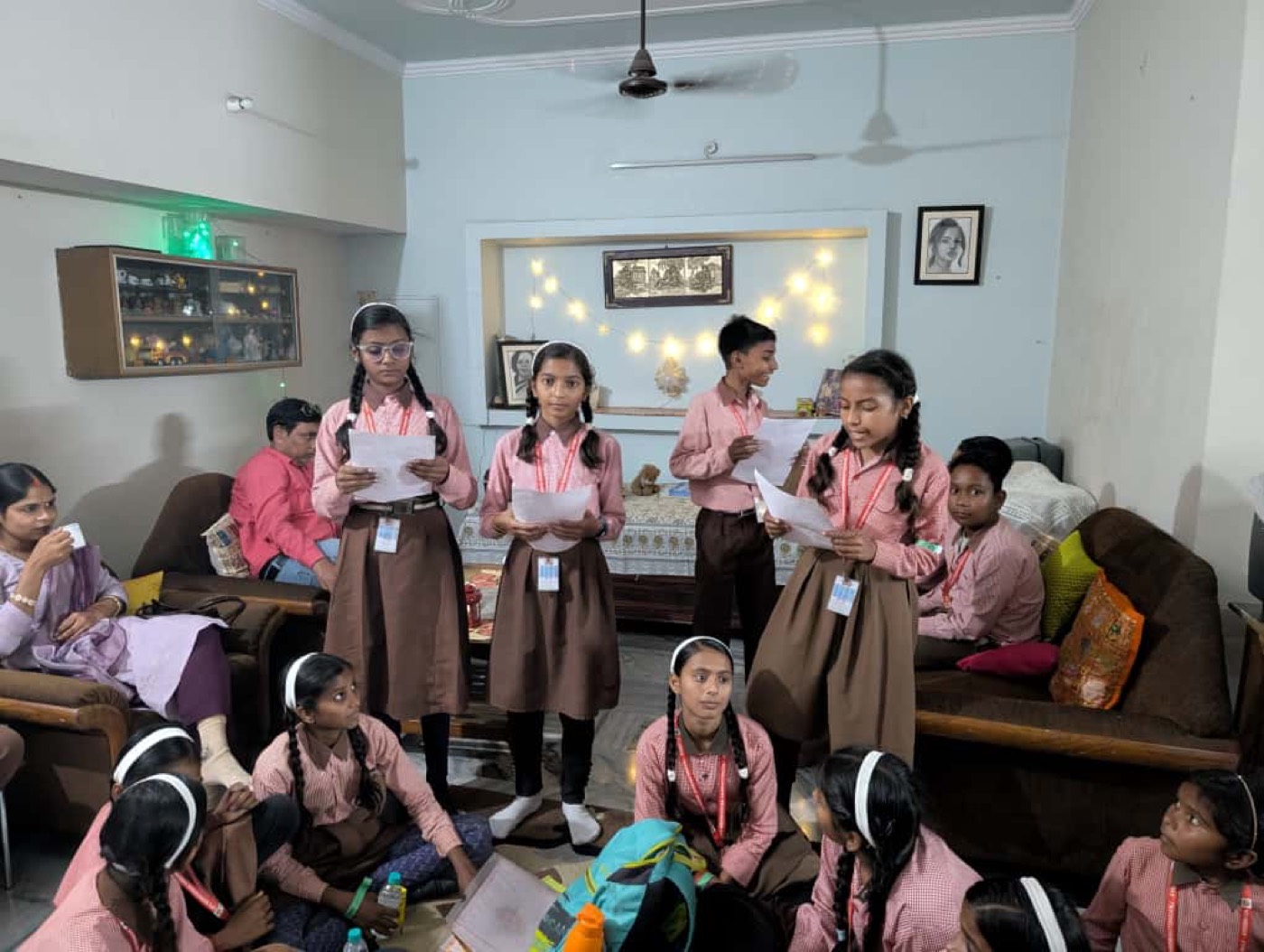 Students standing and reading aloud from their papers while classmates listen